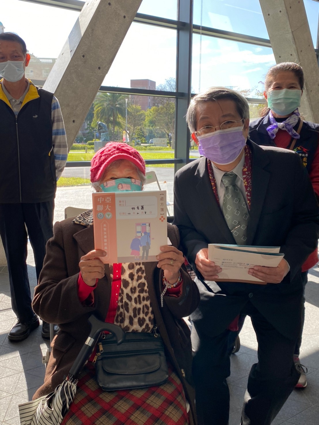 亞美館館長潘襎(右)發放「失智藝術處方箋」，給北柳失智關懷據點長輩